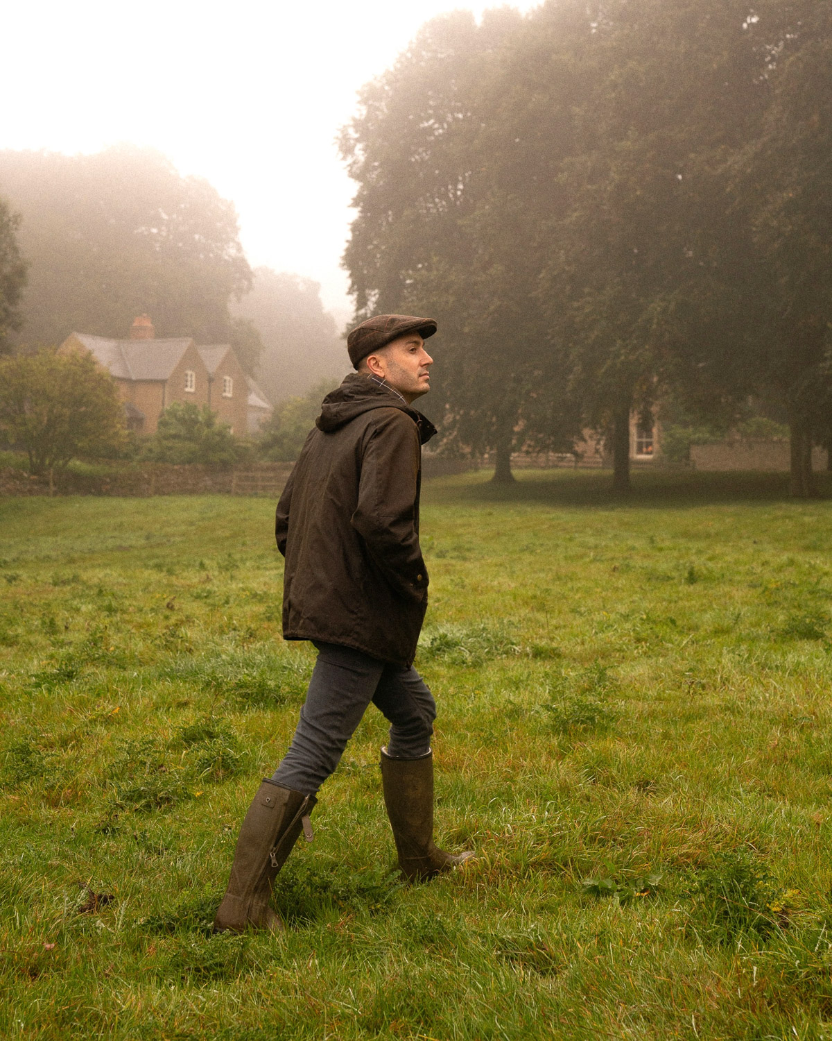 A man in Barbour clothing on a foggy morning in the British countryside, photographed for content creation.